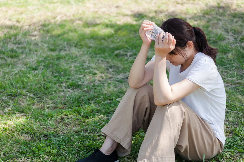 暑さでへたり込んでしまったいる女性